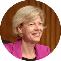 Tammy Baldwin smiles in her headshot while addressing someone off camera.